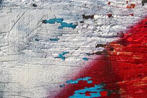 A fragment of colorful graffiti painted on a wooden board with peeling paint close-up. Abstract backdrop for design. photo