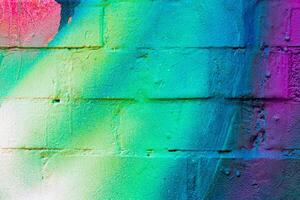 A fragment of colorful graffiti painted on a brick wall. Abstract backdrop for design. photo
