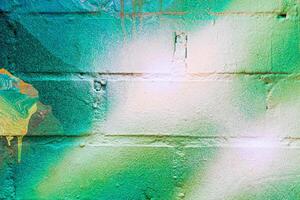 A fragment of colorful graffiti painted on a brick wall. Abstract backdrop for design. photo