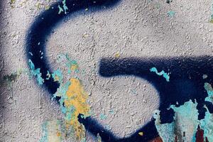A fragment of colorful graffiti painted on a concrete wall. Abstract urban backdrop for design. photo