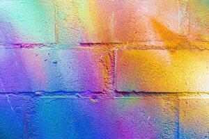 A fragment of colorful graffiti painted on a brick wall. Abstract backdrop for design. photo