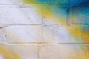 A fragment of colorful graffiti painted on a brick wall. Abstract backdrop for design. photo