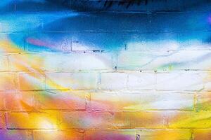 A fragment of colorful graffiti painted on a brick wall. Abstract backdrop for design. photo