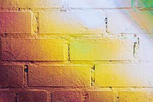 A fragment of colorful graffiti painted on a brick wall. Abstract backdrop for design. photo