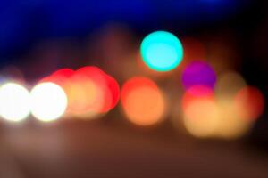 Blurred lights of headlights of cars and lanterns in the night city. Abstract bokeh. photo