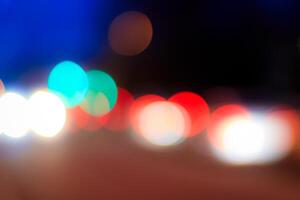 Blurred lights of headlights of cars and lanterns in the night city. Abstract bokeh. photo