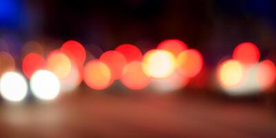 Blurred lights of headlights of cars and lanterns in the night city. Abstract bokeh. photo