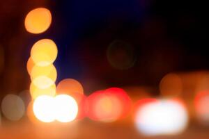 Blurred lights of headlights of cars and lanterns in the night city. Abstract bokeh. photo