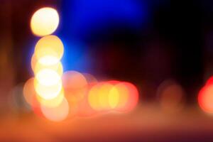 Blurred lights of headlights of cars and lanterns in the night city. Abstract bokeh. photo