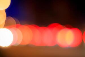Blurred lights of headlights of cars and lanterns in the night city. Abstract bokeh. photo