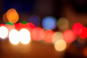 Blurred lights of headlights of cars and lanterns in the night city. Abstract bokeh. photo