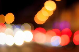Blurred lights of headlights of cars and lanterns in the night city. Abstract bokeh. photo