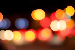 Blurred lights of headlights of cars and lanterns in the night city. Abstract bokeh. photo