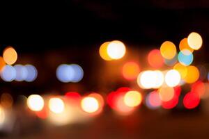 Blurred lights of headlights of cars and lanterns in the night city. Abstract bokeh. photo