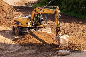 Russia, Kaluga - OCTOBER 27, 2020 A tractor with a bucket leveling a plot of land for construction. photo