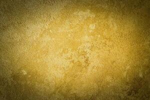 Golden decorative plaster texture with vignette. Abstract grunge background with copy space. photo