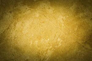 Golden decorative plaster texture with vignette. Abstract grunge background with copy space. photo