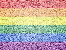 Rainbow LGBTQ or gay pride flag on wallpaper texture. Abstract background. photo