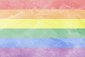 Rainbow LGBTQ or gay pride flag on decorative plaster or concrete texture. Abstract background. photo