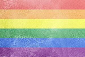 Rainbow LGBTQ or gay pride flag on decorative plaster or concrete texture. Abstract background. photo