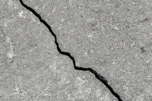 Cracked texture of gray concrete. Abstract background. photo
