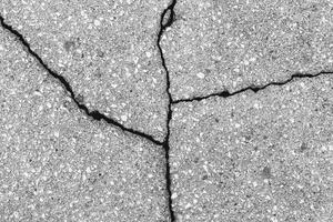 Cracked texture of gray asphalt. Abstract background. photo