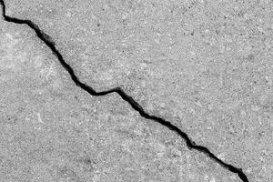 Cracked texture of gray concrete. Abstract background. photo