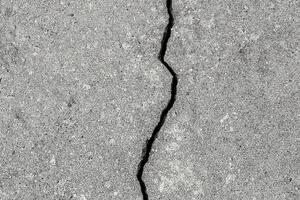 Cracked texture of gray concrete. Abstract background. photo