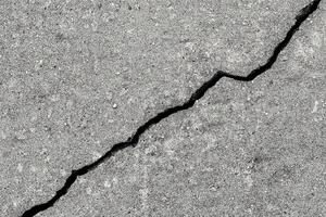 Cracked texture of gray concrete. Abstract background. photo