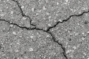 Cracked texture of gray asphalt. Abstract background. photo