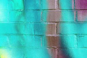 A fragment of colorful graffiti painted on a wall. Abstract urban background. photo
