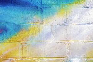 A fragment of colorful graffiti painted on a wall. Abstract urban background. photo