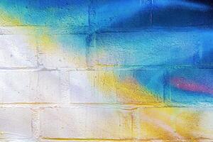 A fragment of colorful graffiti painted on a wall. Abstract urban background. photo