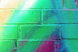 A fragment of colorful graffiti painted on a wall. Abstract urban background. photo