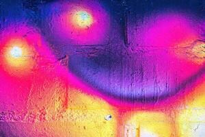 A fragment of colorful graffiti painted on a wall. Abstract urban background. photo