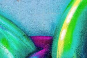 A fragment of colorful graffiti painted on a wall. Abstract urban background. photo