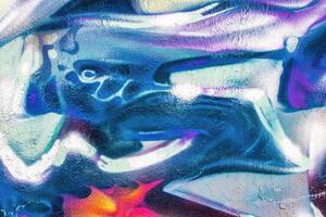 A fragment of colorful graffiti painted on a wall. Abstract urban background. photo