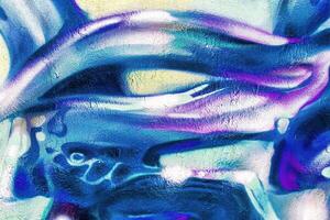 A fragment of colorful graffiti painted on a wall. Abstract urban background. photo