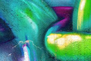 A fragment of colorful graffiti painted on a wall. Abstract urban background. photo