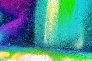 A fragment of colorful graffiti painted on a wall. Abstract urban background. photo