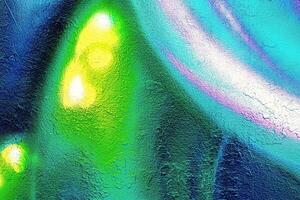 A fragment of colorful graffiti painted on a wall. Abstract urban background. photo