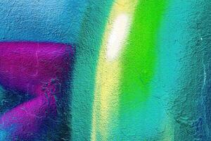 A fragment of colorful graffiti painted on a wall. Abstract urban background. photo