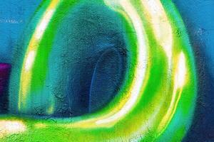 A fragment of colorful graffiti painted on a wall. Abstract urban background. photo