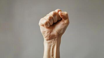 Realistic image of triumphant right hand raised against solid background photo