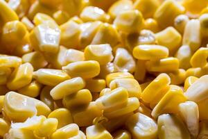 The texture of yellow uncooked corn kernels. photo