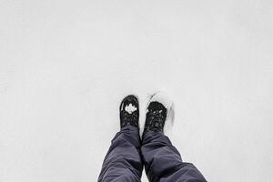 Legs in hiking boots for trekking in the snow. photo