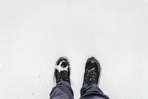 Legs in hiking boots for trekking in the snow. photo