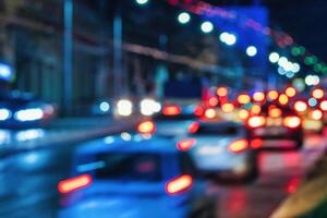 Blurry lights of moving cars and lanterns reflecting on the wet asphalt in the night city. photo