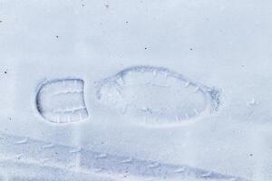 Boot track on thin first snow in winter. photo