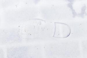 Boot track on thin first snow in winter. photo